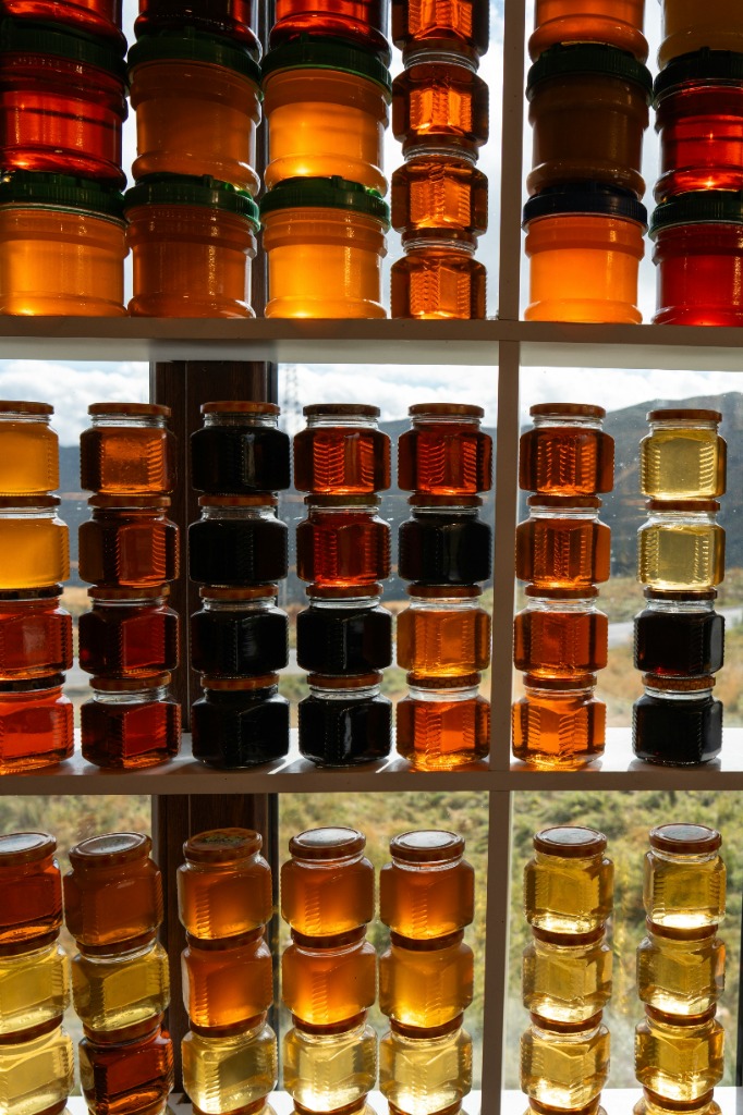 Rows of honey jars on display shelf